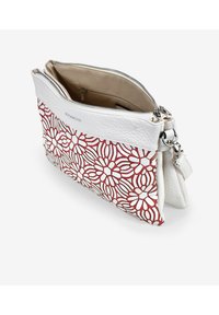 Bolso de mano de cuero blanco con un patrón floral en rojo y blanco, cierre de cremallera y compartimentos interiores. Cuenta con una correa desmontable y herrajes en plata.