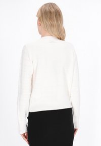 White knitted sweater with horizontal ribbed pattern, round neckline, and long sleeves, ending above the waist. Soft texture.
