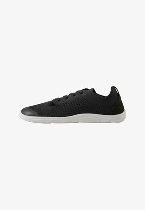 Sneaker bassa in maglia nera con suola bianca texturizzata e chiusura con lacci, con linguetta sul tallone.