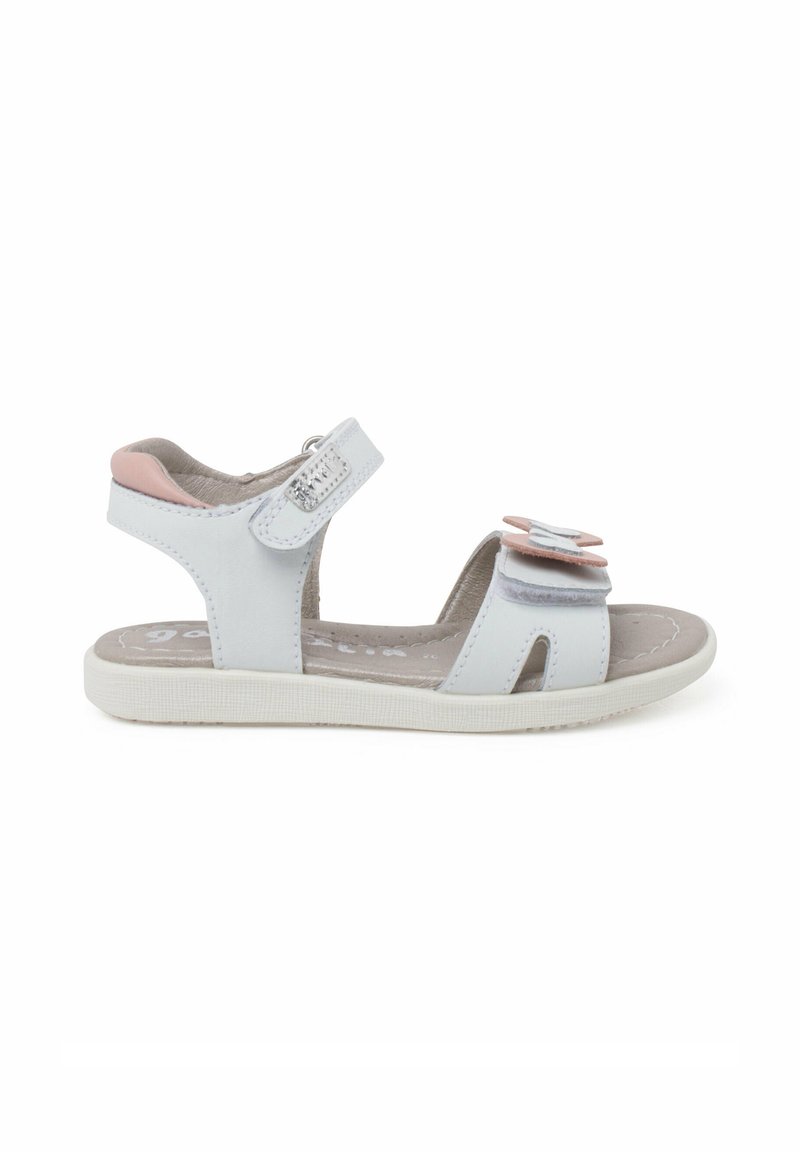 Sandalias blancas con acentos rosas, tiras de velcro y detalles de flores en capas. Fabricadas con material sintético y suela texturizada para mayor agarre.