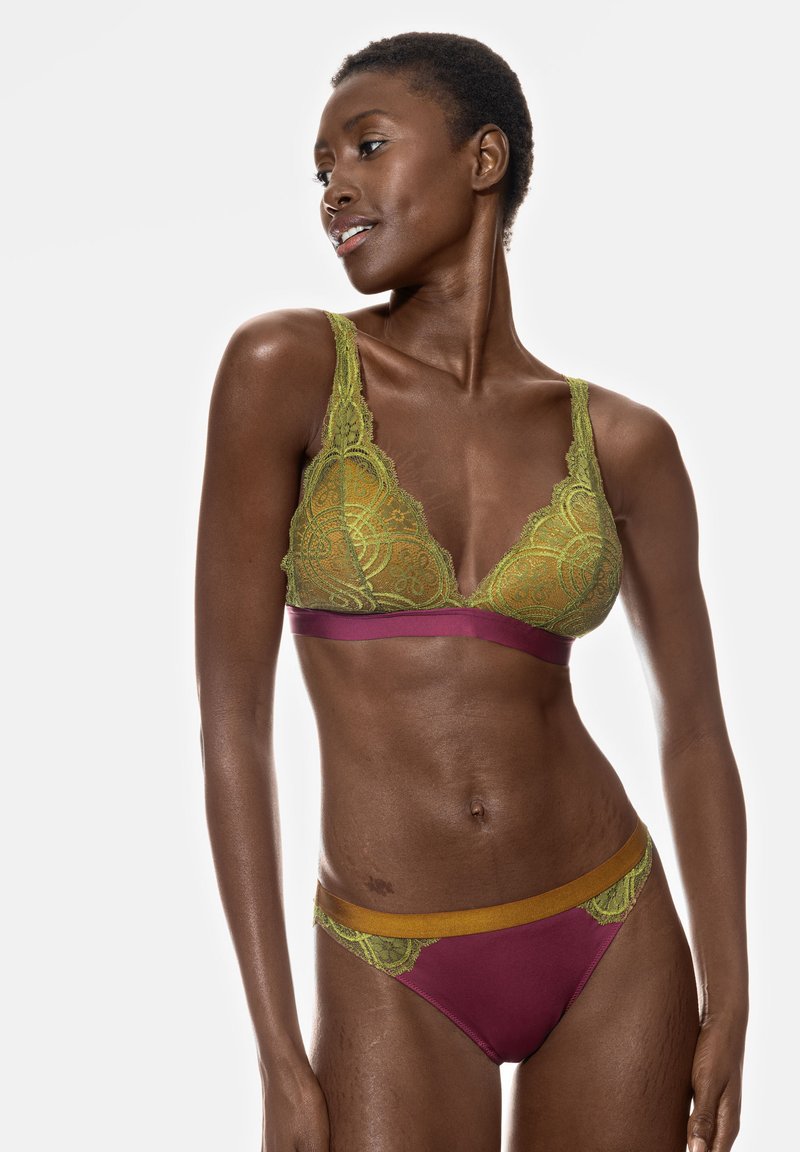 Grön spets-bh med blommönster, med en vinröd rem. Matchande vinröda trosor med grön spetskant och elastiskt midjeband.