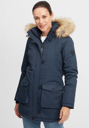 Marineblå parka jacket har en hette med pelsfôr, frontlås med knapper, to store frontlommer og en figursydd design.