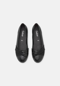 Ballerines noires en cuir lisse avec une sangle élastique entrecroisée. Intérieur avec un coussinet perforé. Taille 4,5.