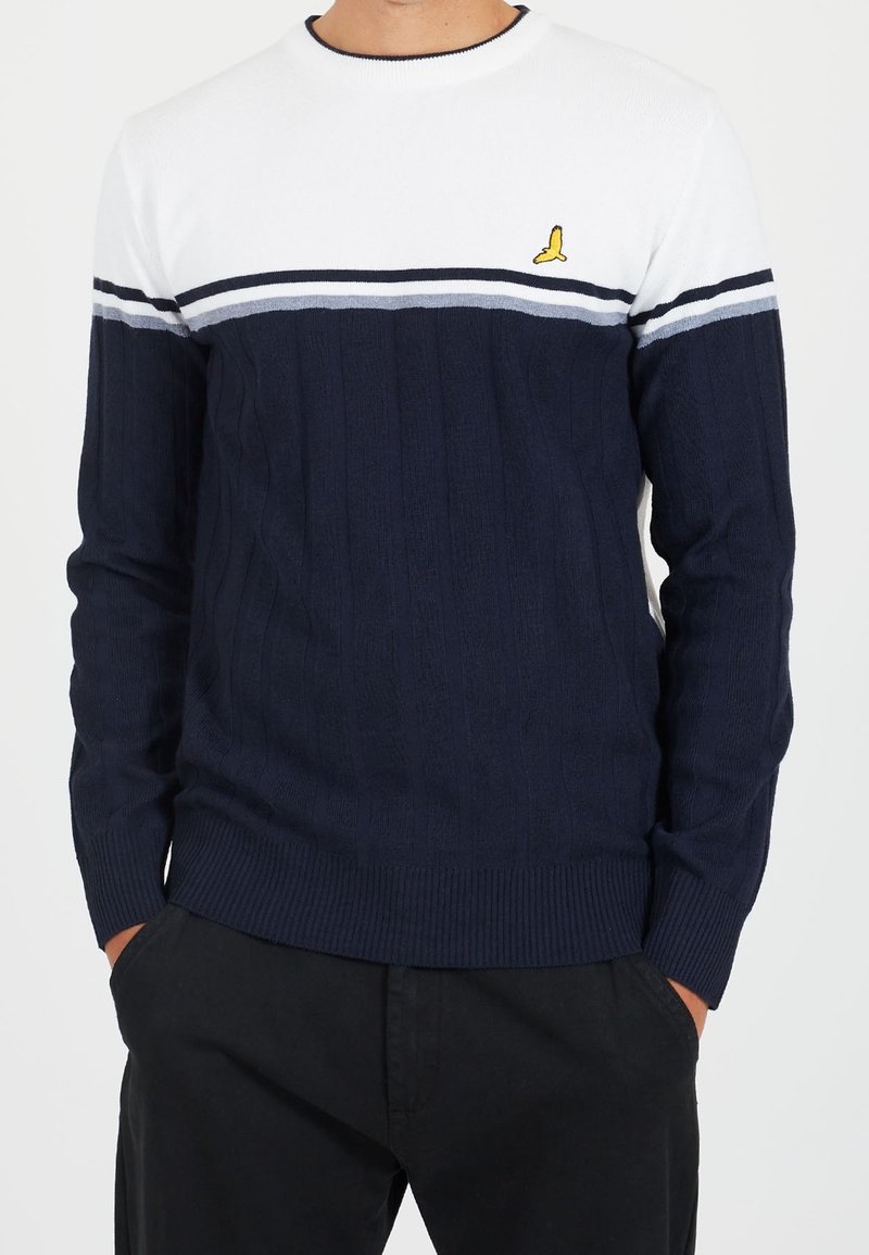 Granatowy sweter z dzianiny z białymi i szarymi poziomymi paskami. Żebrowana struktura, okrągły dekolt i małe żółte logo na klatce piersiowej.