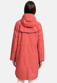 Water-resistant coral parka with a hood, longer back, and adjustable waist. Features a single button closure and contrasting accents.