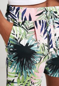 Flerfärgade shorts med ett tropiskt lövmönster. Tillverkade av lättviktsmaterial med dragsko i midjan och plisserad design.