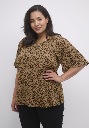Haut marron à manches courtes avec un motif léopard noir. Conçu avec une coupe ample et des fentes sur les côtés pour plus de style et de confort.