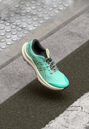 Světlomodrá sportovní bota s texturovaným svrchním materiálem, bílou mezipodešví a šedými akcenty. Obsahuje tkaničky, perforace a polstrovaný límec.