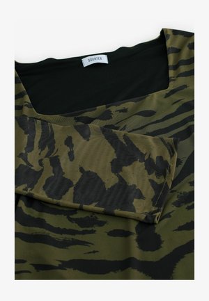 Tissu vert et noir avec un motif rayé tigre ; présente une encolure carrée et une texture douce. L'étiquette indique "SOURTEX."