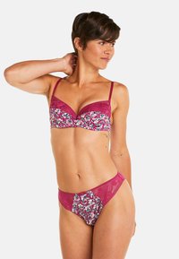 Soutien-gorge magenta et culotte assortie, ornés de motifs floraux et d'accents en dentelle. Le tissu est doux avec des coutures décoratives et un design structuré.