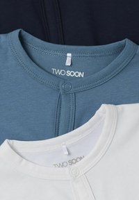 Tre baby bodysuits i blått, marinblått och vitt. Mjuk bomullstyg med tryckknappar och med varumärket "TWO SOON" på etiketter.