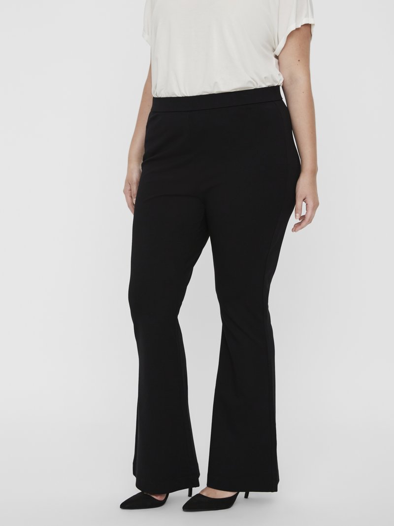 Μαύρο καμπάνα παντελόνι από ελαστικό ύφασμα με απαλή υφή και φαρδιά μέση, συνδυασμένο με μαύρες γόβες με μυτερή μύτ η.