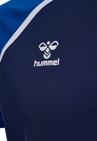 Marineblauw sportshirt met blauw en witte accenten, uitgerust met een gestructureerde stof en een wit "hummel" logo op de borst.