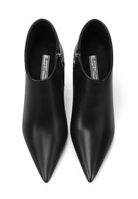 Gli stivali neri in pelle fino alla caviglia presentano un design con punta appuntita, cerniere laterali e una superficie liscia. L'interno è dotato di un'etichetta con il marchio.