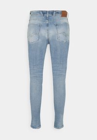 Světle modré džíny skinny s vybledlým detailem, dvěma zadními kapsami, poutek na opasek a hnědým ko ženým štítkem na pásu.