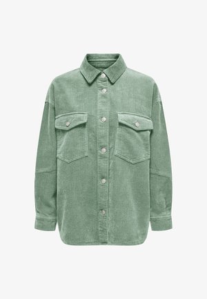 Groen corduroy overhemd met een kraag, zilveren knoopsluitingen en twee borstzakken met kleppen. Zachte, textuurrijke afwerking met een geribd patroon.
