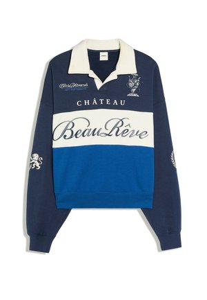 Kleurgebloemde navy, witte en blauwe longsleeve met witte kraag, handgeschreven tekst "Beau Rêve," en decoratieve geborduurde ontwerpen op borst en mouwen.
