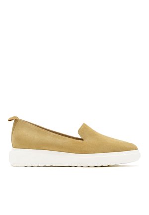 Lysebrun ruskind slip-on sko med lav hæl og tykk hvid gummisål, designet til afslappet brug.