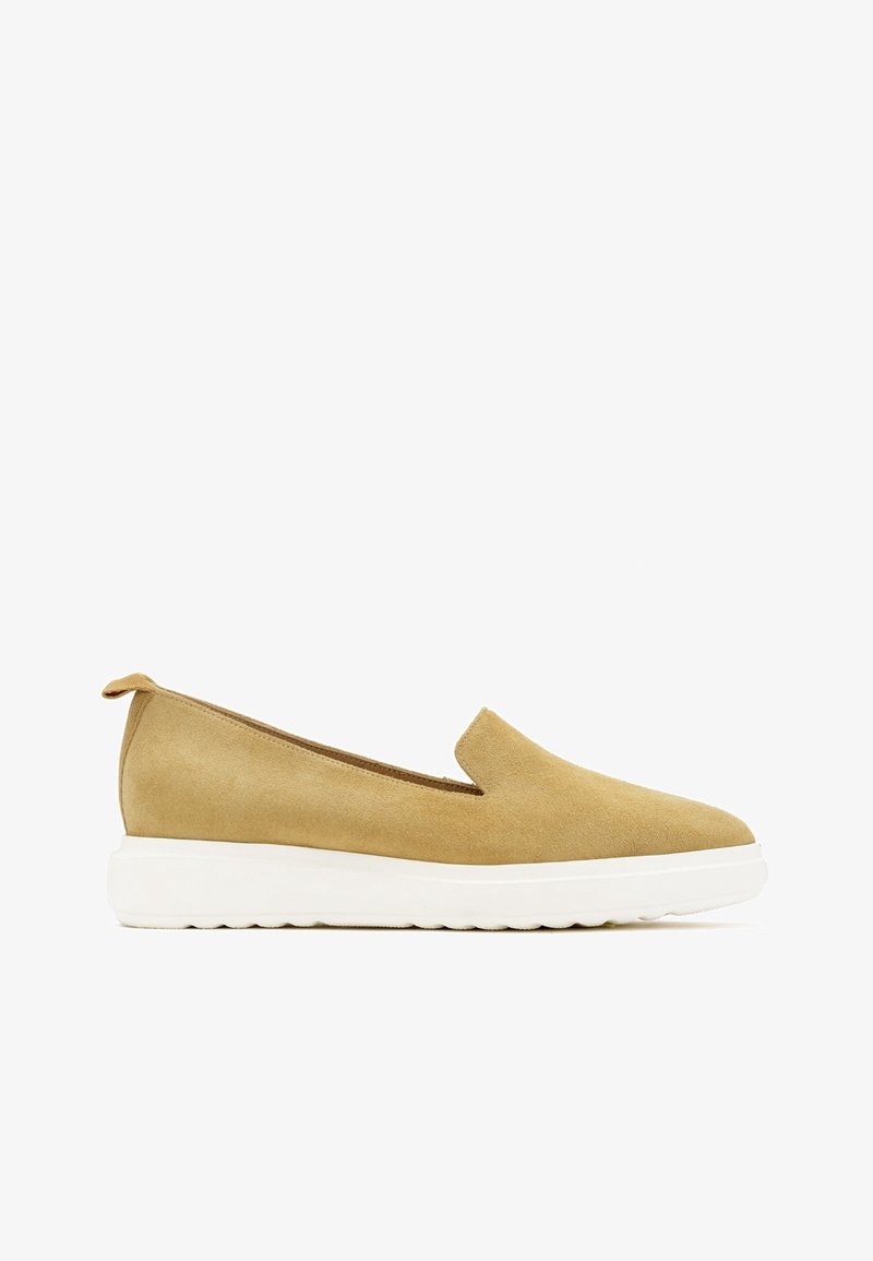Chaussure en daim marron clair à enfiler, avec un petit talon et une semelle épaisse en caoutchouc blanc, conçue pour un usage décontracté.