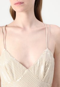 Bežna obleka s sequins z nežnimi naramnicami, V-izrezom in oprijetim korzetom z teksturiranim vzorcem okroglih sequins.