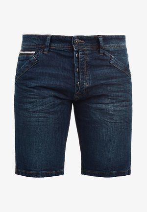 Tumši zili džinsu šorti ar pogu priekšā, piecām kabatām un kontrastējošiem diegiem. Audumam ir gluda tekstūra ar nelielu izbalējumu.