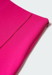 Fuchsia kokerrok gemaakt van soepele stof, met een zijrits en een gestikte voorplooi voor extra detail.