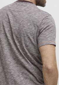Gray melange t-shirt with a smooth texture, short sleeves, and a contrasting dark collar. Features subtle stitch detail at the sleeve edge.