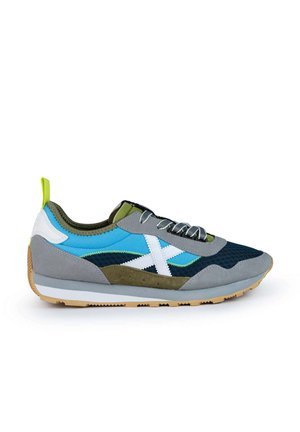 Zapatilla deportiva con una mezcla de gamuza y malla en azul, gris y verde. Presenta detalles en blanco, una puntera texturizada y suela de goma.