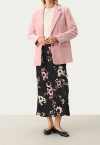 Rosa cordflöjl blazer, vit t-shirt och svart blommig kjol med rosa och krämfärgade mönster. Svarta ballerina skor fulländar outfiten.