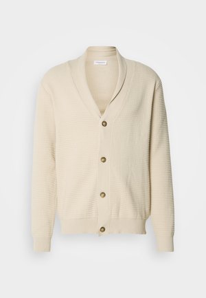 Beige cardigan met een gebreid textuurpatroon, sjaalkraag en vijf ronde goudkleurige knopen aan de voorkant. Geribbelde manchetten en zoom.