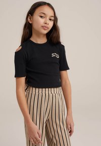 Černý žebrovaný crop top s krátkými rukávy, který má vykrojená ramena a nápis "JDI S TOKEM." Spárováno s béžovými pruhovanými širokými kalhotami.