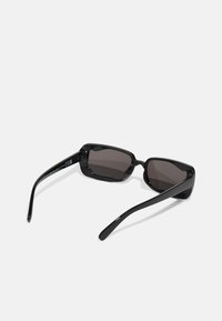 Black rectangular sunglasses with dark lenses, featuring sleek plastic frames and straight arms. Subtle design accents on the frame.
