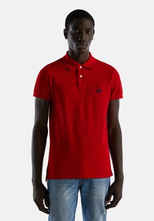 Camisa polo roja de algodón, con un cuello clásico, dos botones y un pequeño logotipo bordado en el lado izquierdo del pecho. Corte informal.