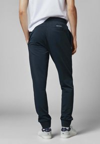 Pantalones deportivos azul marino con una textura suave, cinturilla elástica y cordón ajustable. Cuenta con un bolsillo trasero con el logo "Pepe Jeans".