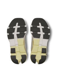 Les chaussures de sport présentent des semelles en caoutchouc avec des crampons noirs, une texture à motifs et une base gris clair. Des accents jaunes mettent en valeur le design de la semelle intermédiaire.