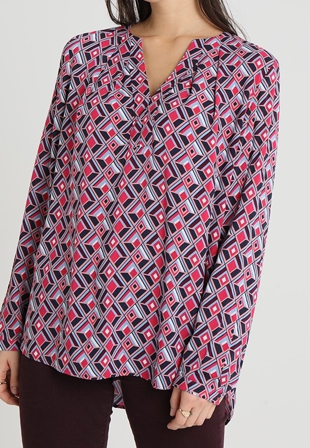 Chemisier à manches longues en rose, bleu marine et blanc avec un motif géométrique, décolleté en V et plis ; tissu doux, ourlet arrondi, coupe décontractée.