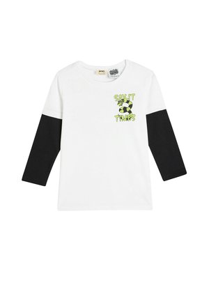Hvid T-shirt med sorte lange ærmer, prydet med et grønt og sort grafisk design med teksten "SIG DET 3 GANGE" og et fodboldmotiv.
