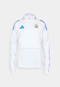 Wei�ßer sportlicher Pullover mit langen Ärmeln, halber Reißverschluss und blauen Akzenten. Verfügt über das Wappen von Real Madrid und Adidas-Logos. Glatte Textur.