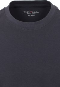 Donkergrijze premium katoenen t-shirt met een ronde hals, met een gladde textuur en subtiele stiksels. Etiket maat medium zichtbaar.
