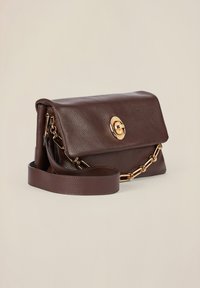 Bolso de mano de cuero marrón con un acabado texturizado, detalles en hardware dorado, cierre de solapa y una correa ajustable. Incluye un detalle de cadena.