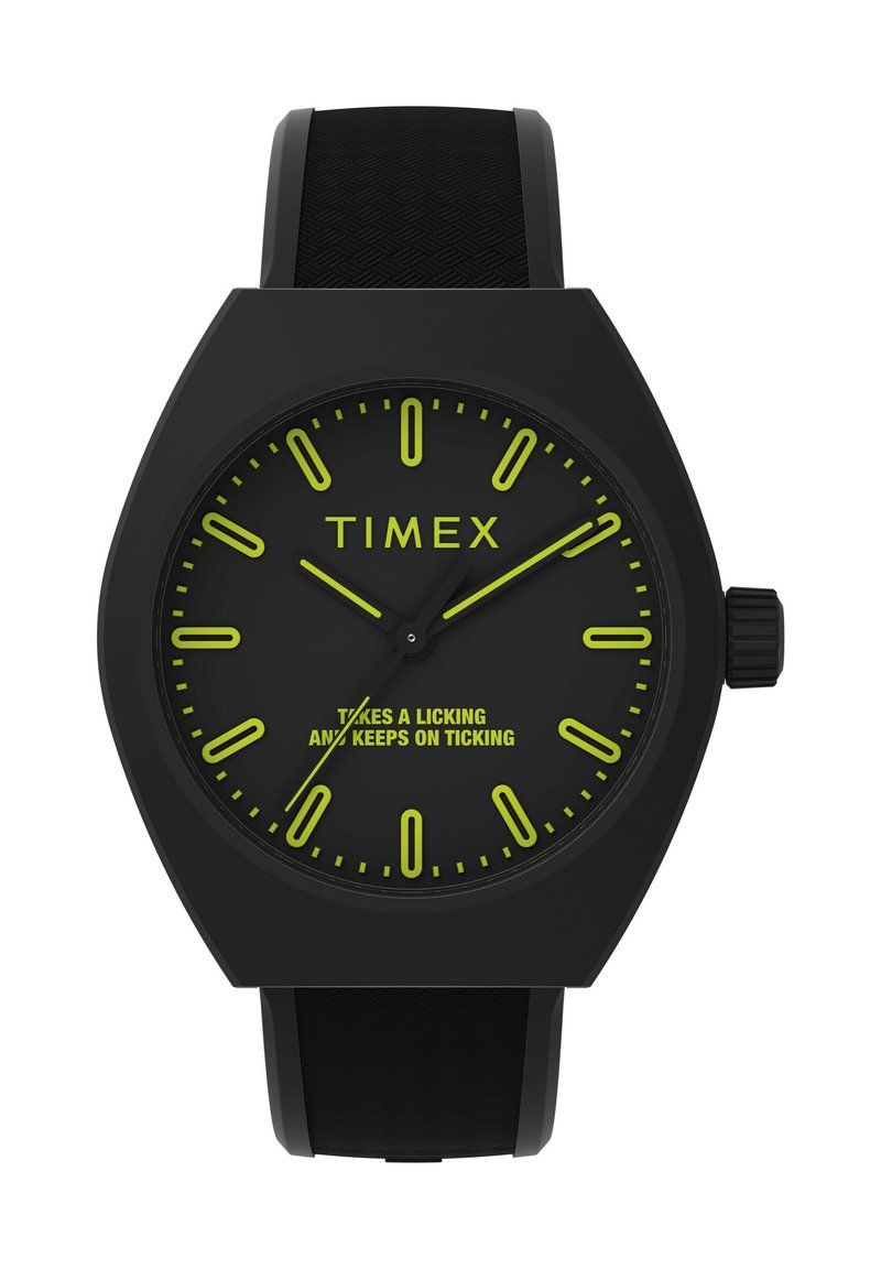 Melna Timex pulksteņa ar sešstūra korpusu, melnu silikona siksniņu, gaismas zaļiem stundu rādītājiem un tekstu uz ciparnīcas: "Iztur lielus izaicinājumus un turpina darboties."