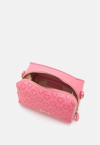 Rosa Valentino crossbody väska med präglad logotyp och guldblixtlås delvis öppet, vilket avslöjar beige inredning.