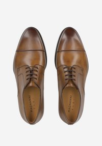 Chaussures habillées en cuir marron avec une finition lisse, un design à lacets, un bout arrondi et des détails de couture minimaux. Semelle intérieure marquée "Magnanni Flex."