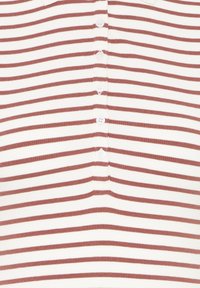 Weißer Stoff mit horizontalen rostfarbenen Streifen und einer zentralen Reihe von fünf kleinen weißen Knöpfen.