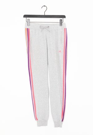 Hellgraue Adidas Sweathosen mit pinken, lila und orangen Streifen an den Seiten, Kordelzug in der Taille und elastischen Bündchen, hängen an einem schwarzen Bügel.