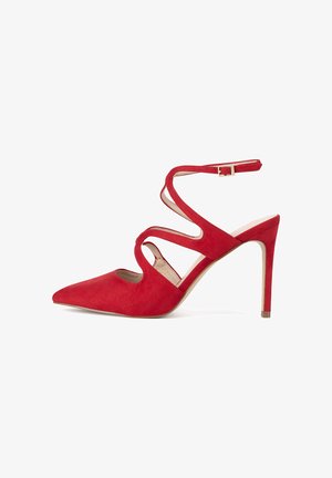Rote Wildleder-Pumps mit spitzem Schuhkopf, Knöchelriemen und Ausschnittdesign. Der Absatz ist schlank und verjüngend. Mit einem goldenen Schnallenakzent.
