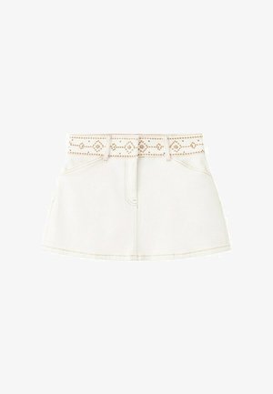 Bijela traper mini suknja s prednjim džepovima i remenom s zakovicama s uzorkom simetričnih dijamanata i linija.