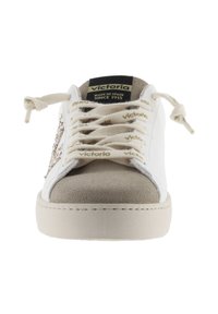 Sneaker bianco con dettagli in suede grigio, punta rotonda e lacci piatti. Presenta il logo sulla linguetta e un pannello laterale decorativo. Suola in gomma testurizzata.