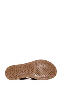 Suela de goma marrón con un patrón texturizado en zigzag y agarres hexagonales para tracción. Perfil plano y construcción robusta.