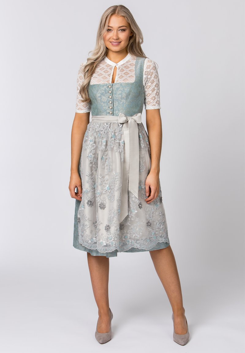Traditionelles Kleid mit einem türkisfarbenen Oberteil, kurzen Spitzenärmeln, einem silbernen Rock mit floralem Stickmuster und einem Satinschleifenband in der Taille.